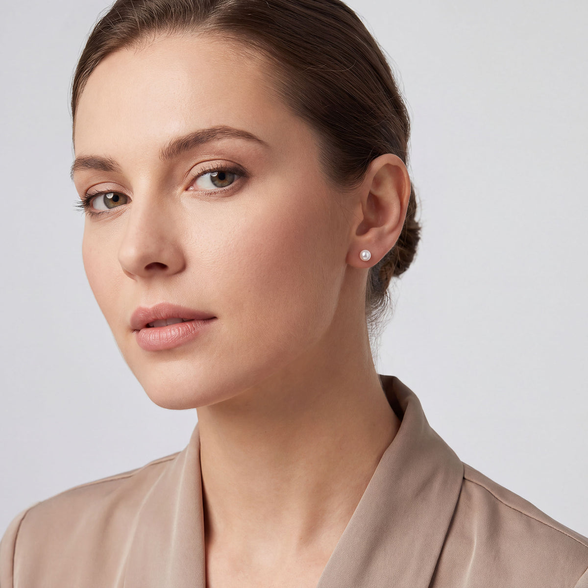 Women's gold-tone stud earrings with a small white pearl