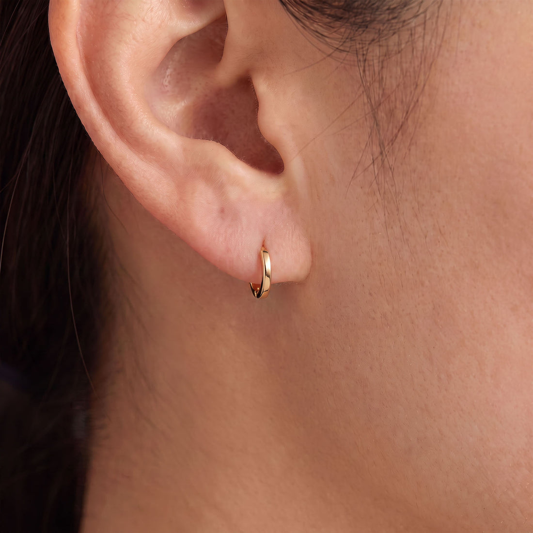Delicate 8 mm gold-tone hoop earrings with a smooth surface and hinge clasp