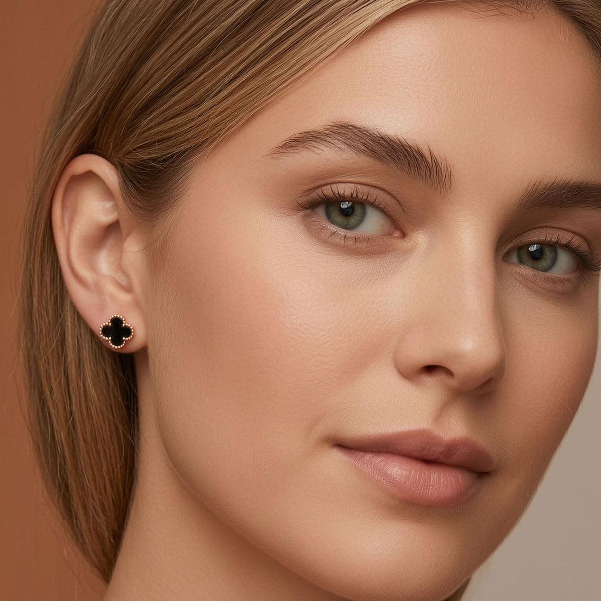 Black clover earrings with a gold-tone border and push-back fastening
