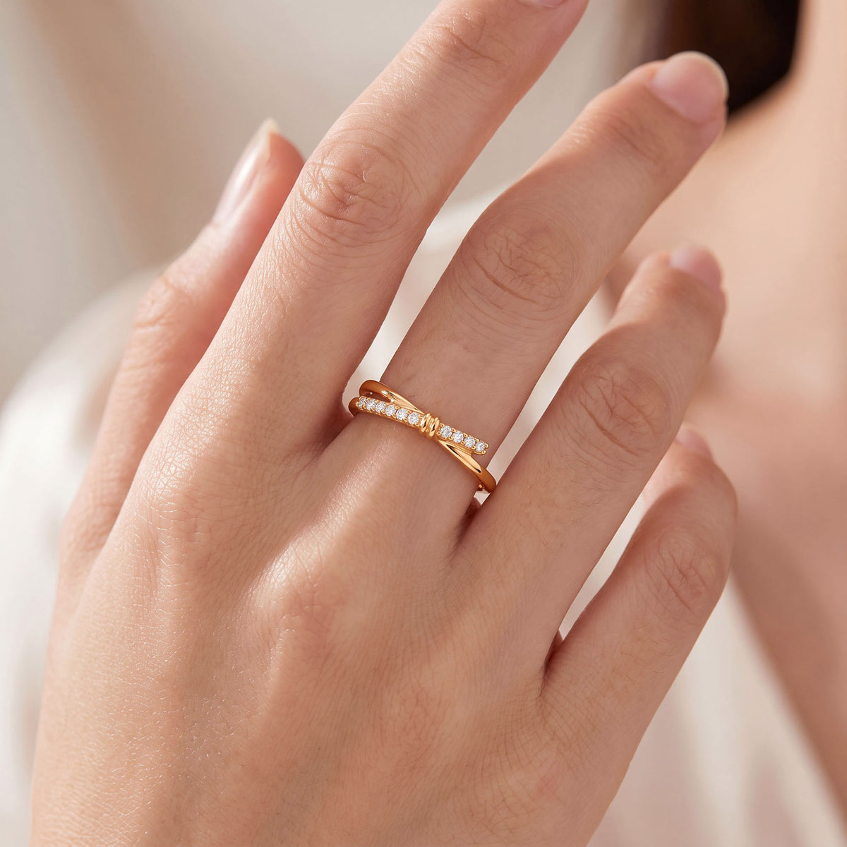 Crossover ring with cubic zirconia worn on a woman's finger
