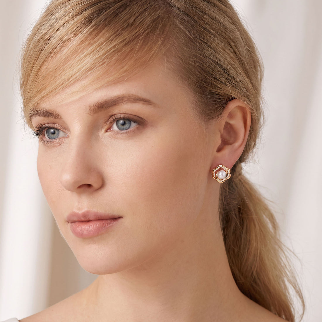 Gold | Gold-tone pearl flower earring worn on the ear