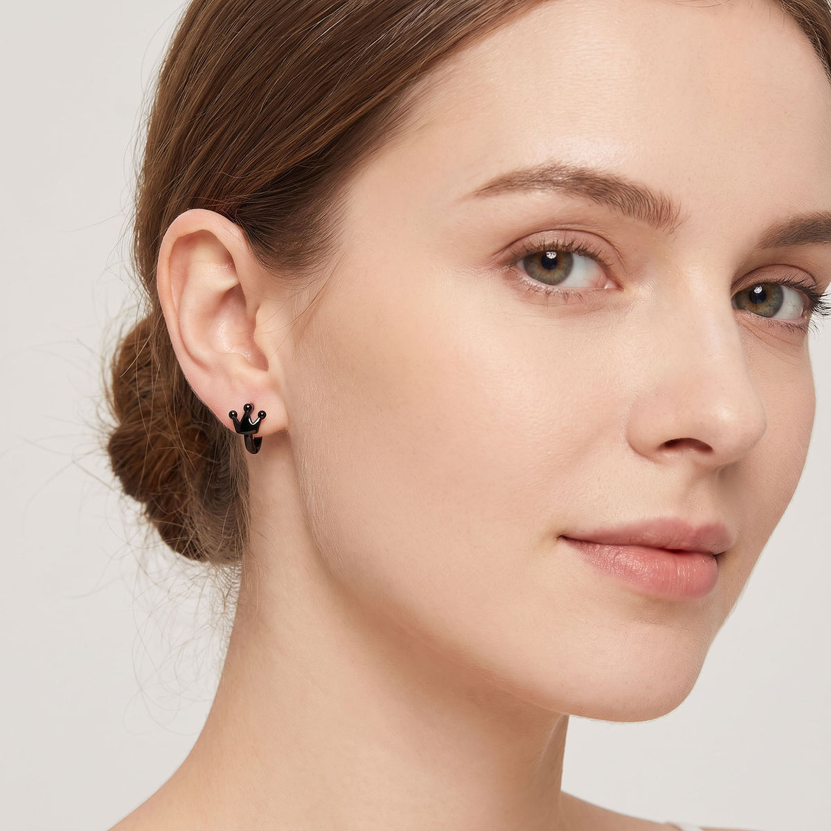Black crown hoop earring worn on the lobe