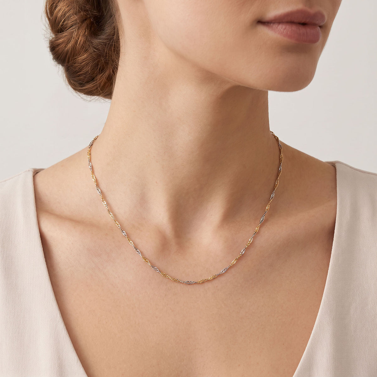 Two-tone Singapore chain in gold and silver tone worn on the neck