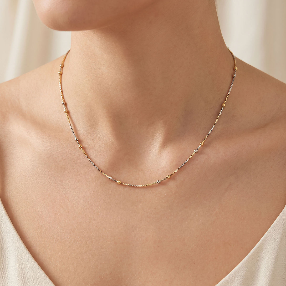 Two-tone beaded chain worn on a woman's neck