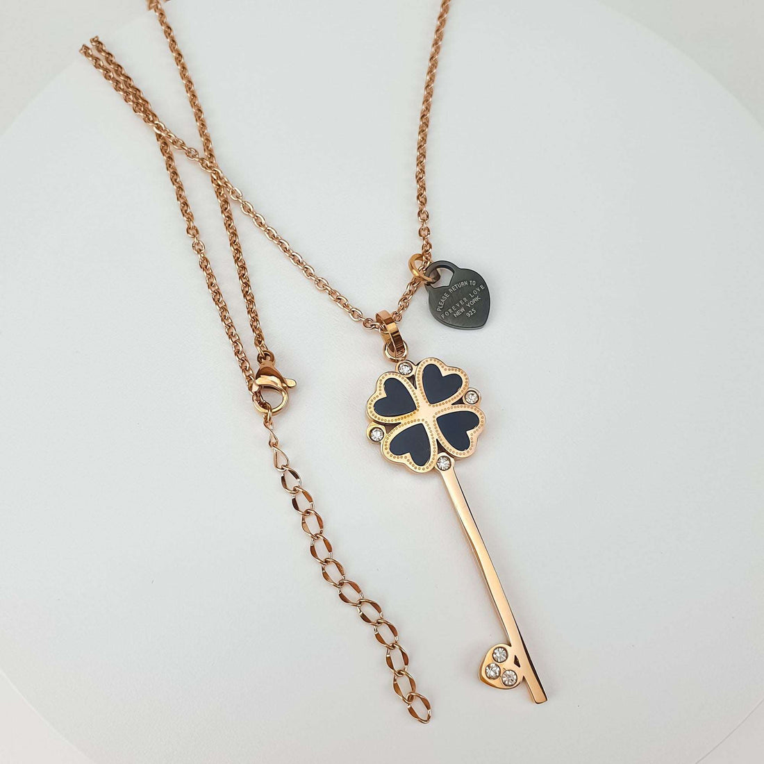 Rose gold-tone key necklace laid flat with clasp and extension chain