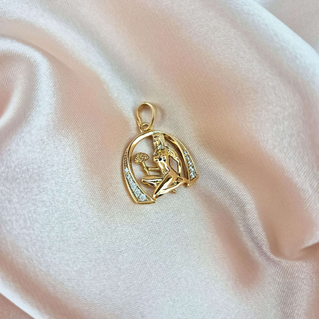 Gold-plated horseshoe pendant with cubic zirconia on cream silk