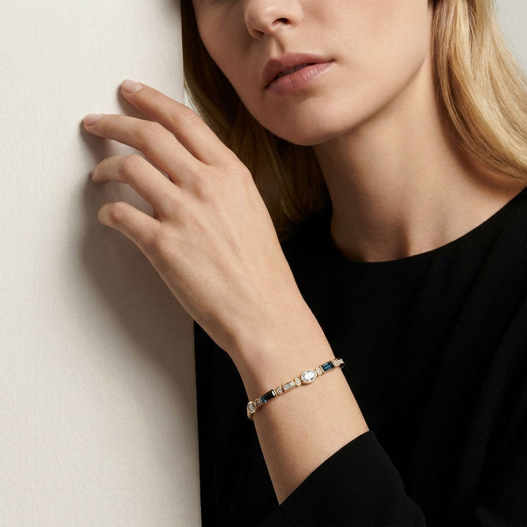 Woman in a black dress wearing the gold-plated bracelet with blue crystals