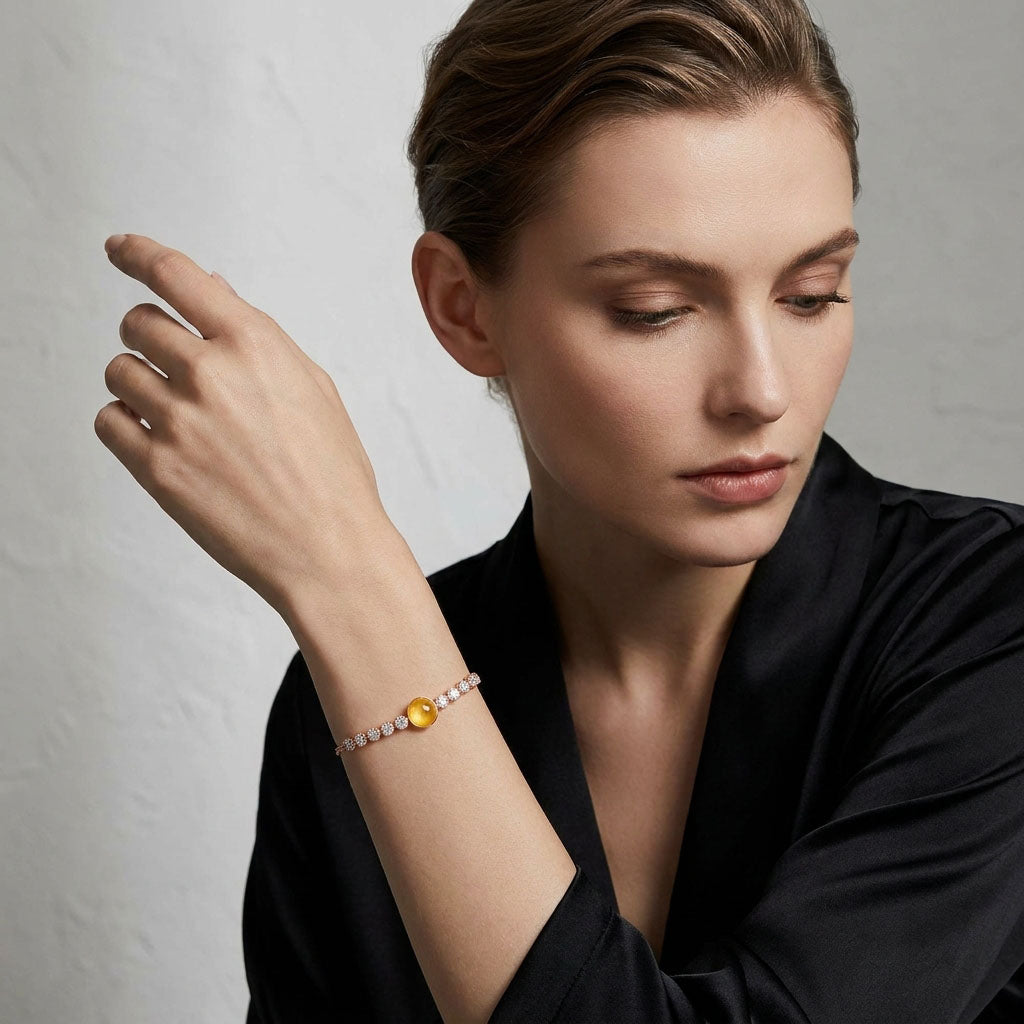 Model in a black silk top wearing the bracelet with a yellow crystal