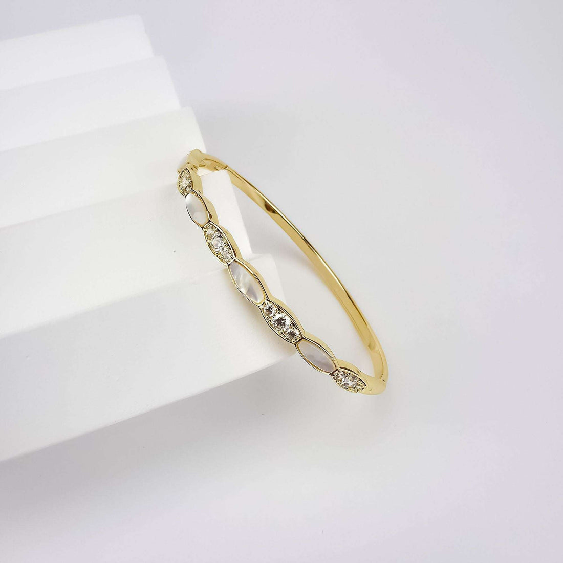 Close-up of the oval link bangle showing white inlays and clear cubic zirconia