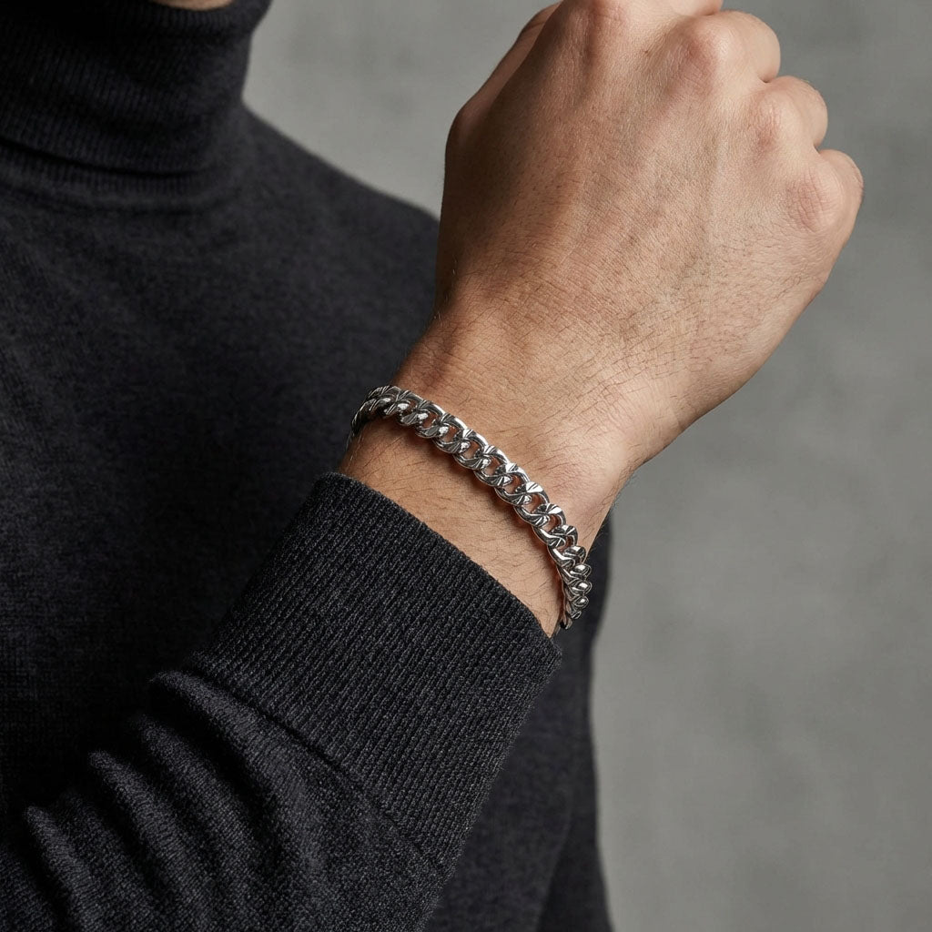 Man in a dark grey jumper wearing a silver-tone chain bracelet
