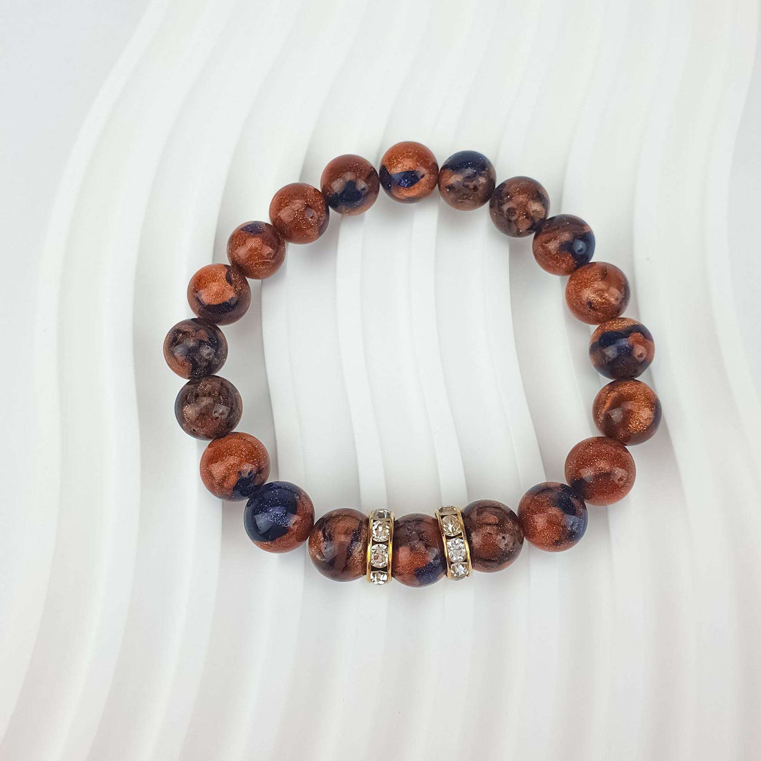 Close-up of glittering brown and bluish beads with two crystal spacers