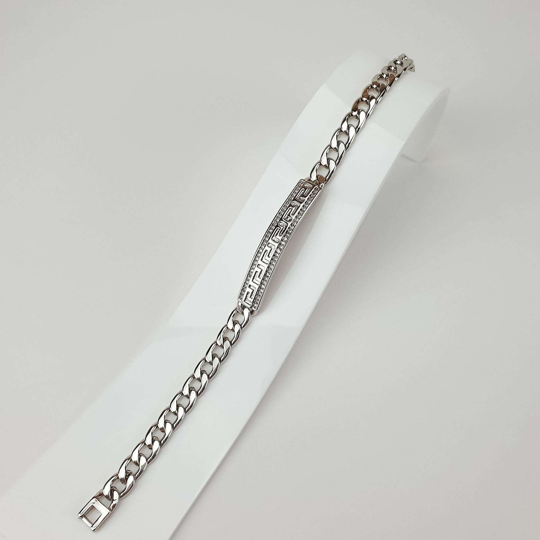 Full-length Greek key bracelet on a white stand, sparkling zirconia border
