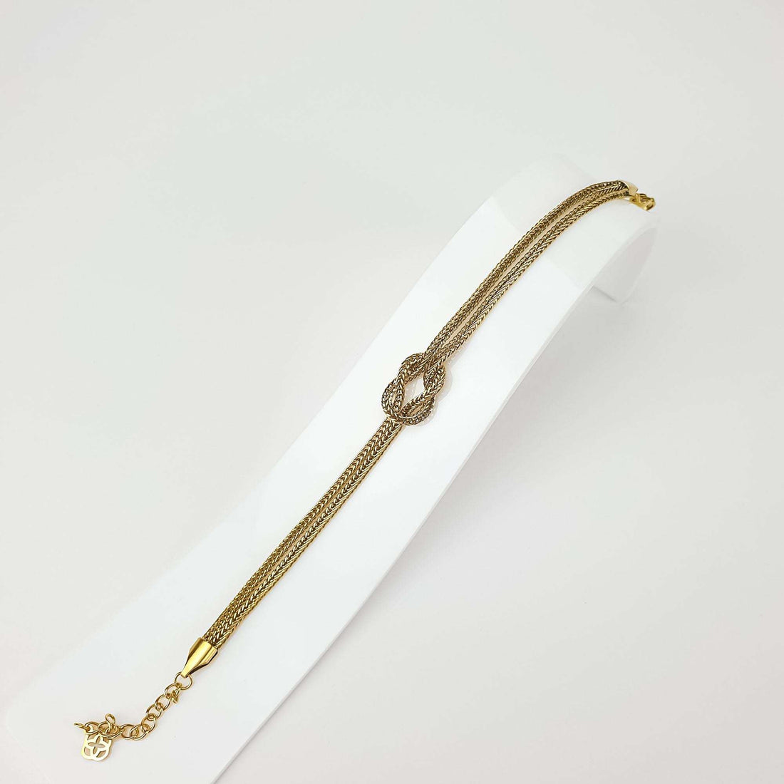 Knot bracelet on a white stand showing the weave and adjustable extension chain