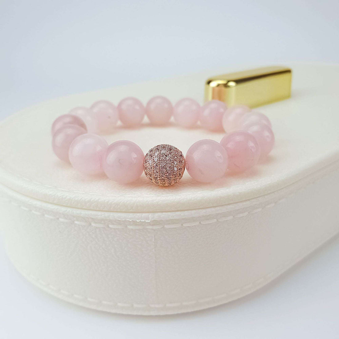Soft pink quartz bracelet with a sparkling zirconia bead on a white jewellery box