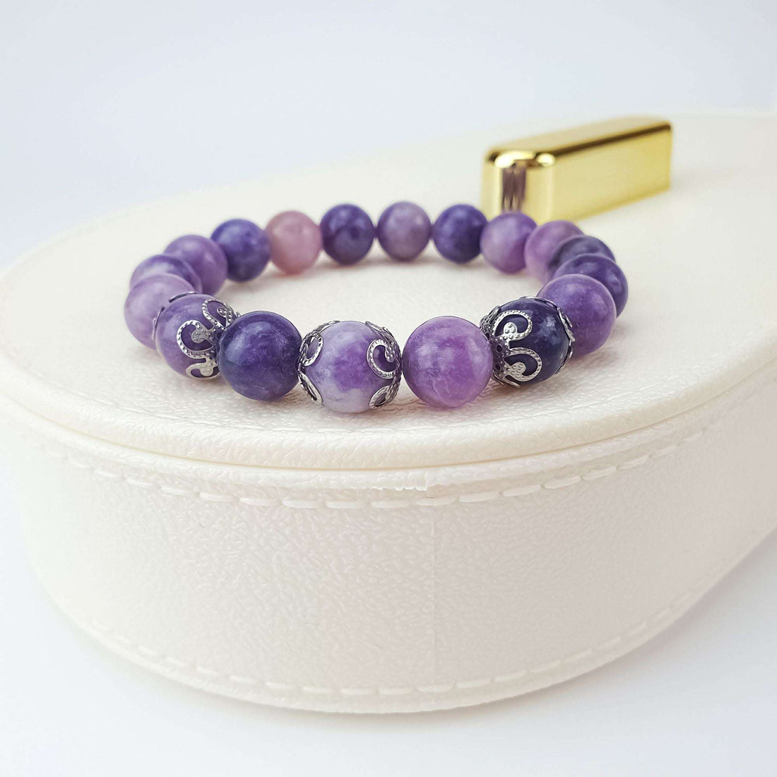 Purple lepidolite bracelet on a light gift box with silver-tone ornamental beads