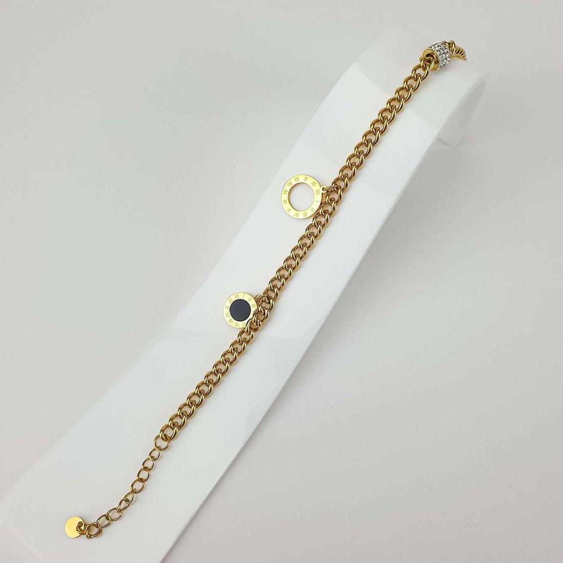 Gold-plated bracelet at an angle with Roman numeral discs and extension chain