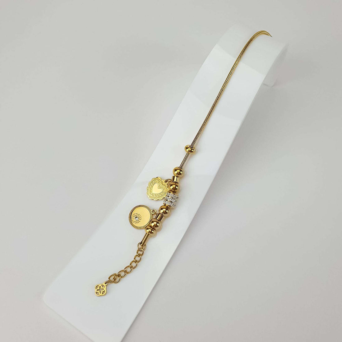 Charm bracelet stretched out on white with extension chain and clover detail