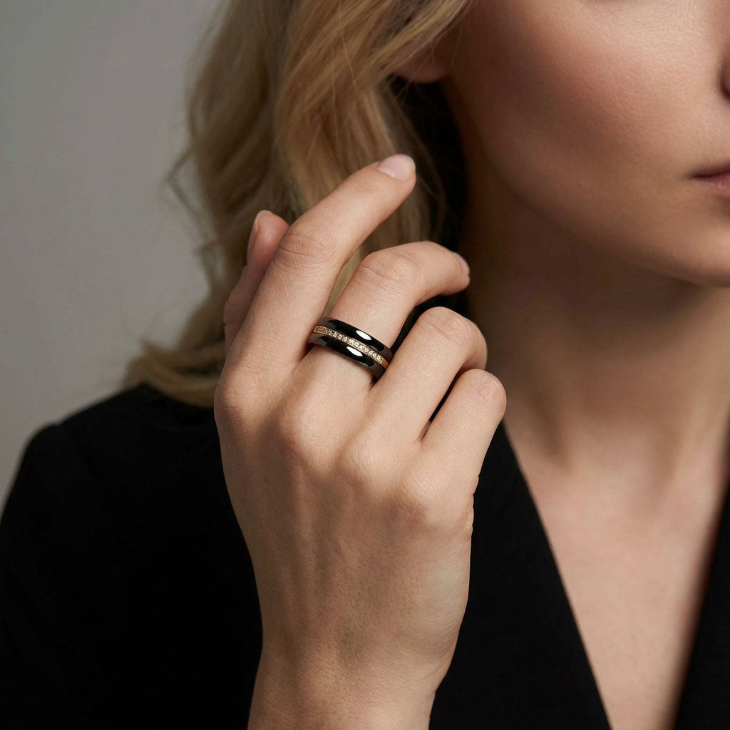 Dark ceramic ring with a gold-plated crystal band on a model in dark clothing