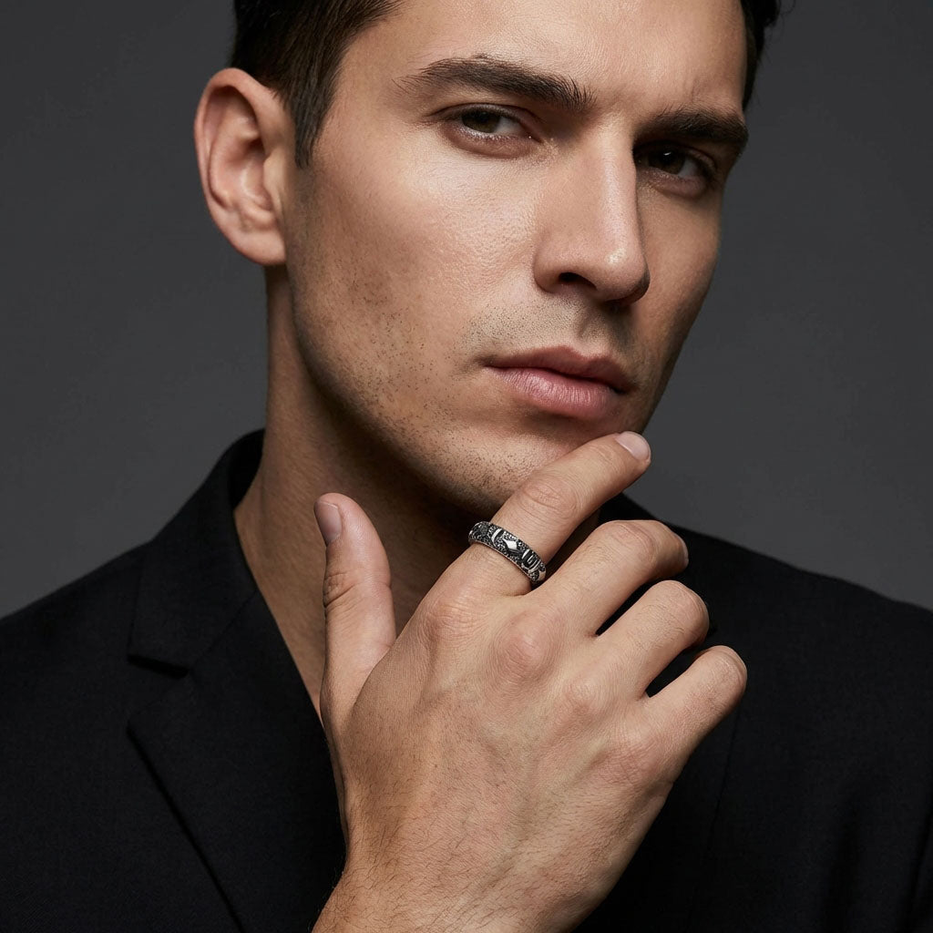 Man in a black jacket wearing a steel ring with embossed symbols