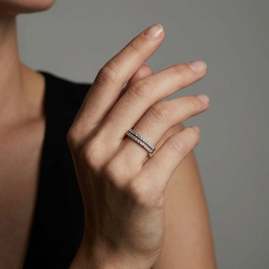 Two-row cubic zirconia ring on a woman's finger, catching the light