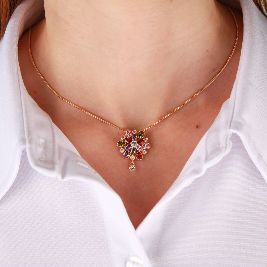 Rose gold-tone snake chain on a model with a colourful cubic zirconia flower pendant