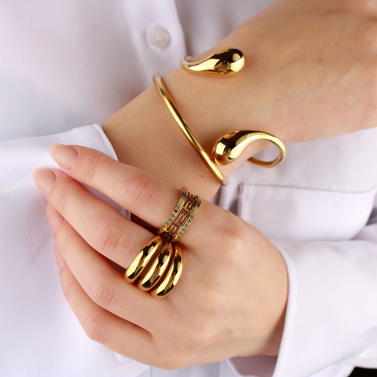 Model wearing the chunky ring with a gold-plated bracelet and a Greek key ring