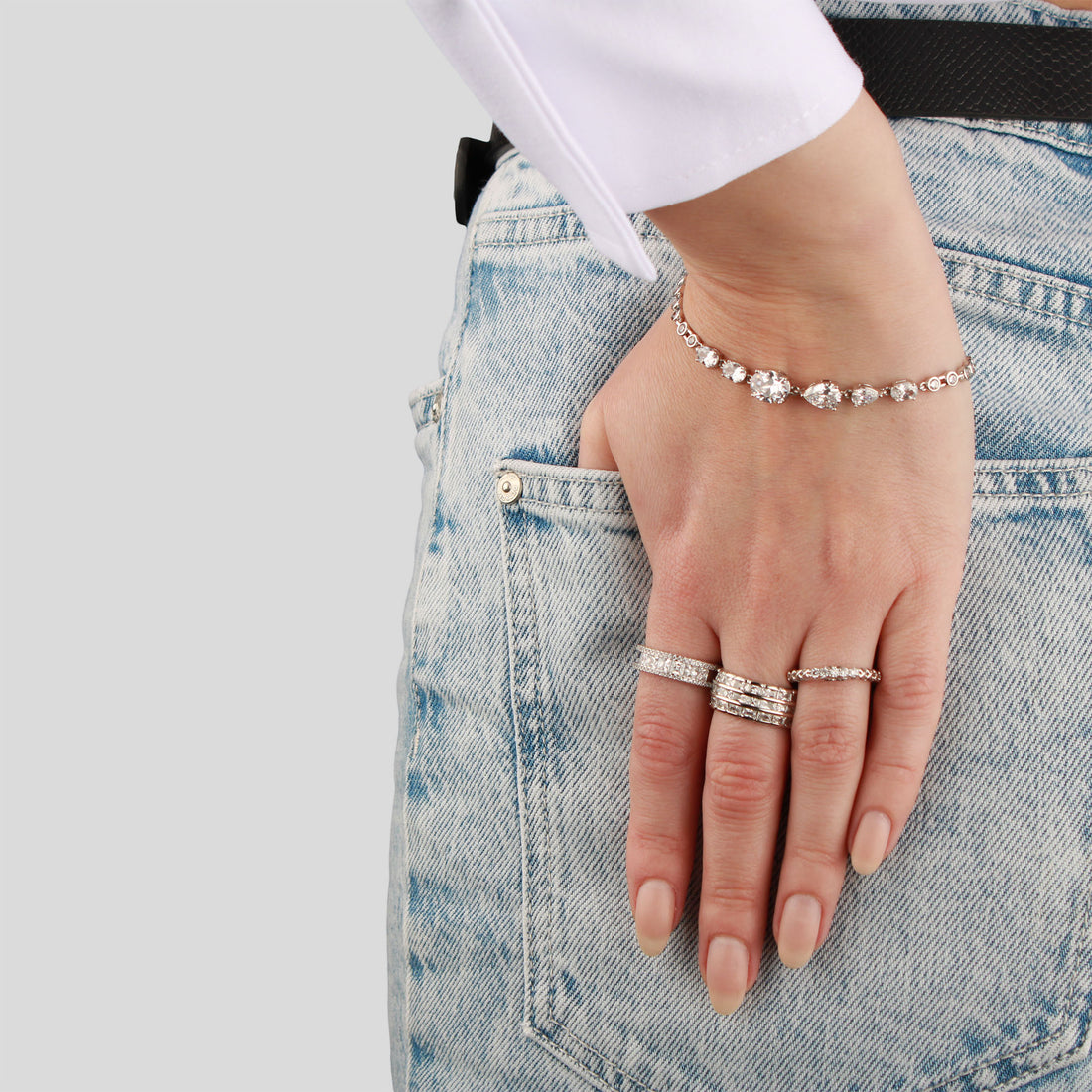 Wide cubic zirconia ring on a model's finger, hand in a light jeans pocket