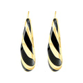 Gold-plated earrings with spiral black enamel stripes and an Omega back on white