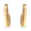 Elongated oval gold-plated hoop earrings with a woven surface pattern on white
