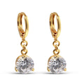 Long gold-plated earrings with a round white stone in a three-prong setting