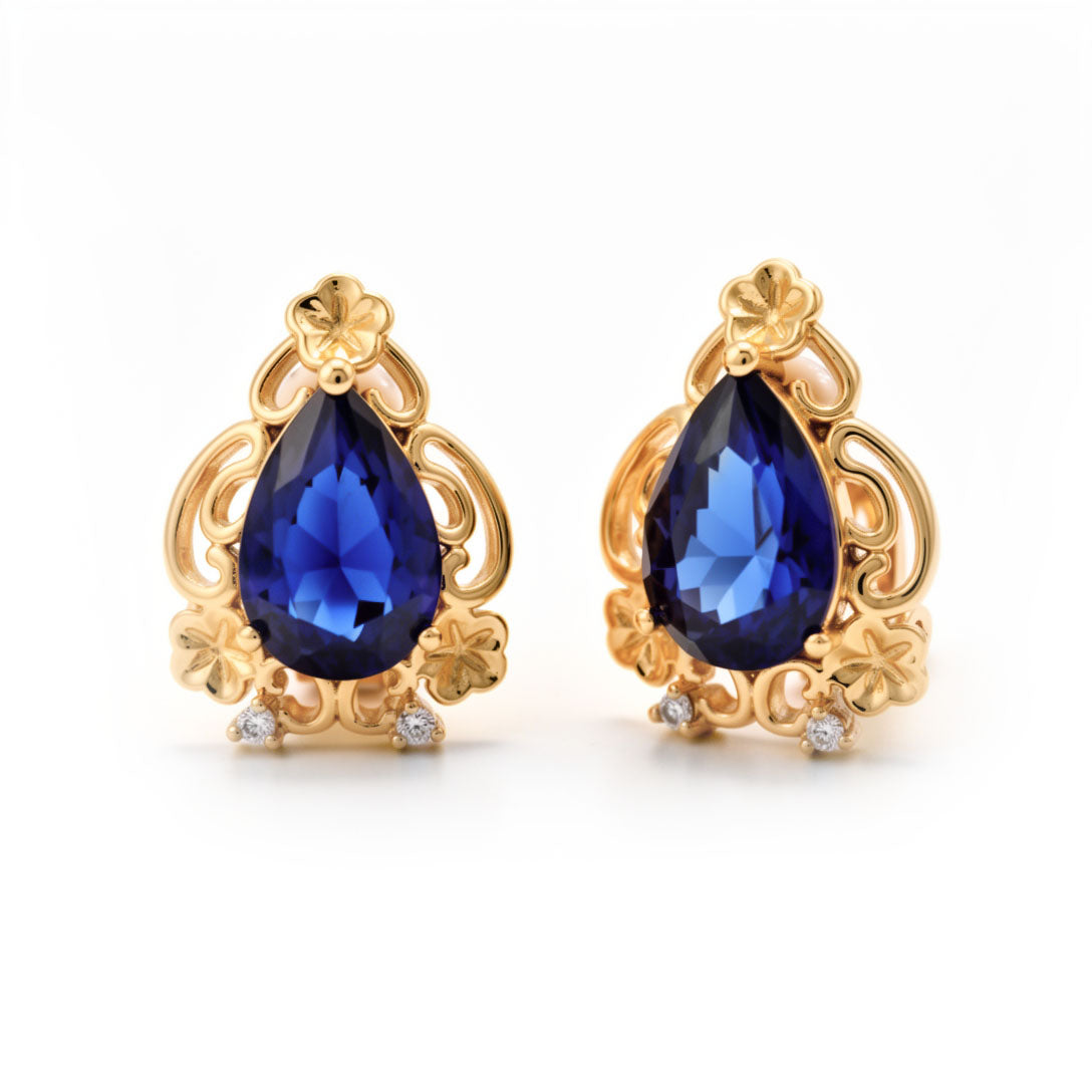 Gold-plated clip-on earrings with a deep blue pear-shaped stone and cubic zirconia