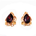 Openwork clip-on earrings with a large dark red teardrop stone, gold-plated