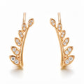 Gold-plated leaf branch ear climbers with white cubic zirconia on a white background