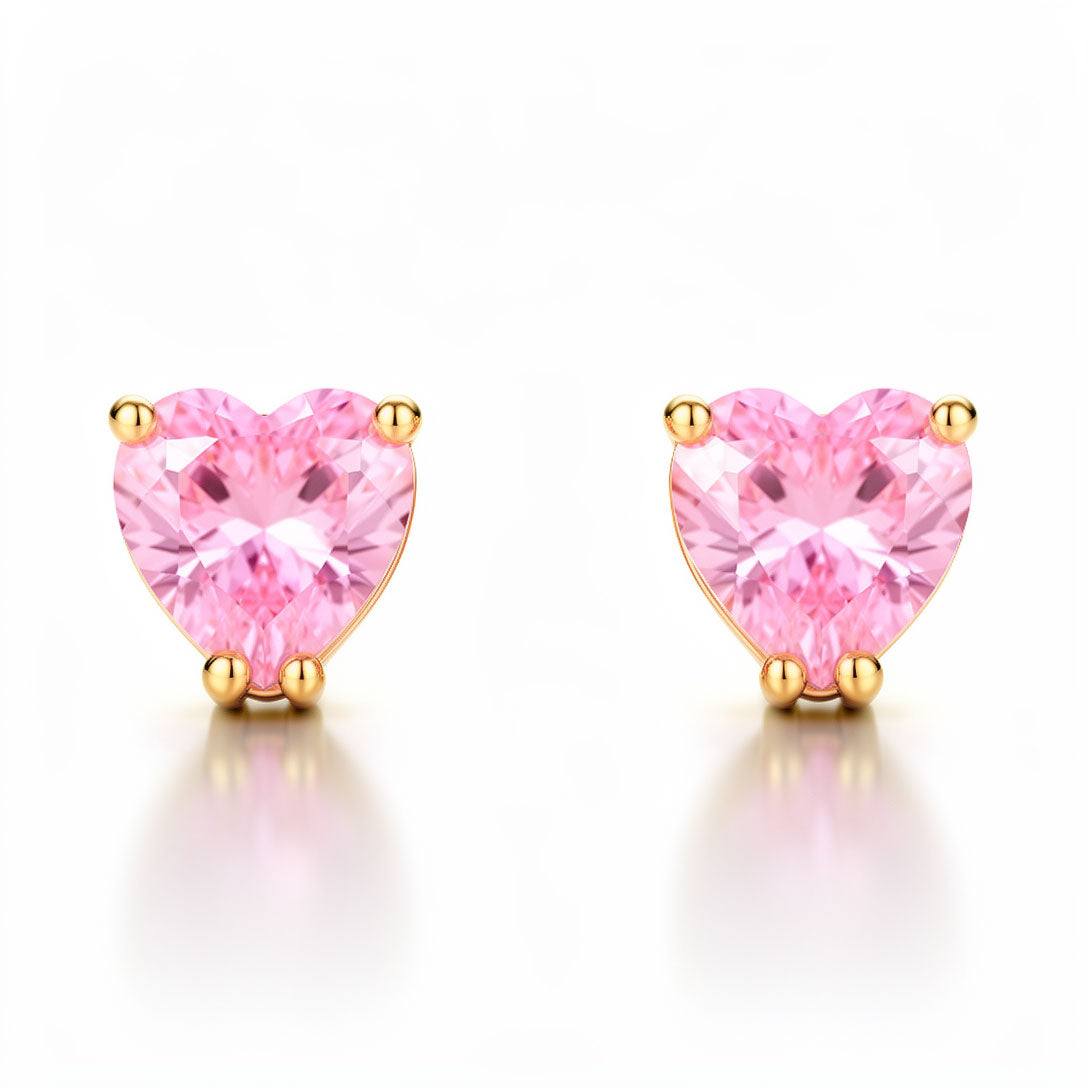 Pink heart cubic zirconia studs in gold-tone settings, close-up on a light background