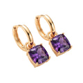 Gold | Gold-tone hoop earrings with square violet crystal drops on a white background