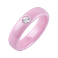 Pale pink ceramic ring with one round clear cubic zirconia and a smooth surface