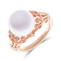 Rosy gold-tone ring with a large white pearl-like stone and small cubic zirconia