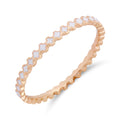 Narrow rose gold-tone ring with white enamel four-petal flowers all around