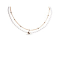 Double-strand necklace with faux pearls and a gold-tone bead chain, white background