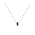 Gold-tone chain with a round pendant and a band of faceted black stones