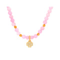 Pink bead necklace with a gold-tone four-leaf clover charm set with cubic zirconia