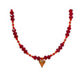 Dark red faceted crystal necklace with a gold-tone heart pendant and golden beads