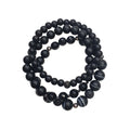 Three black bracelets of matte, faceted and striped beads with silver-tone spacers