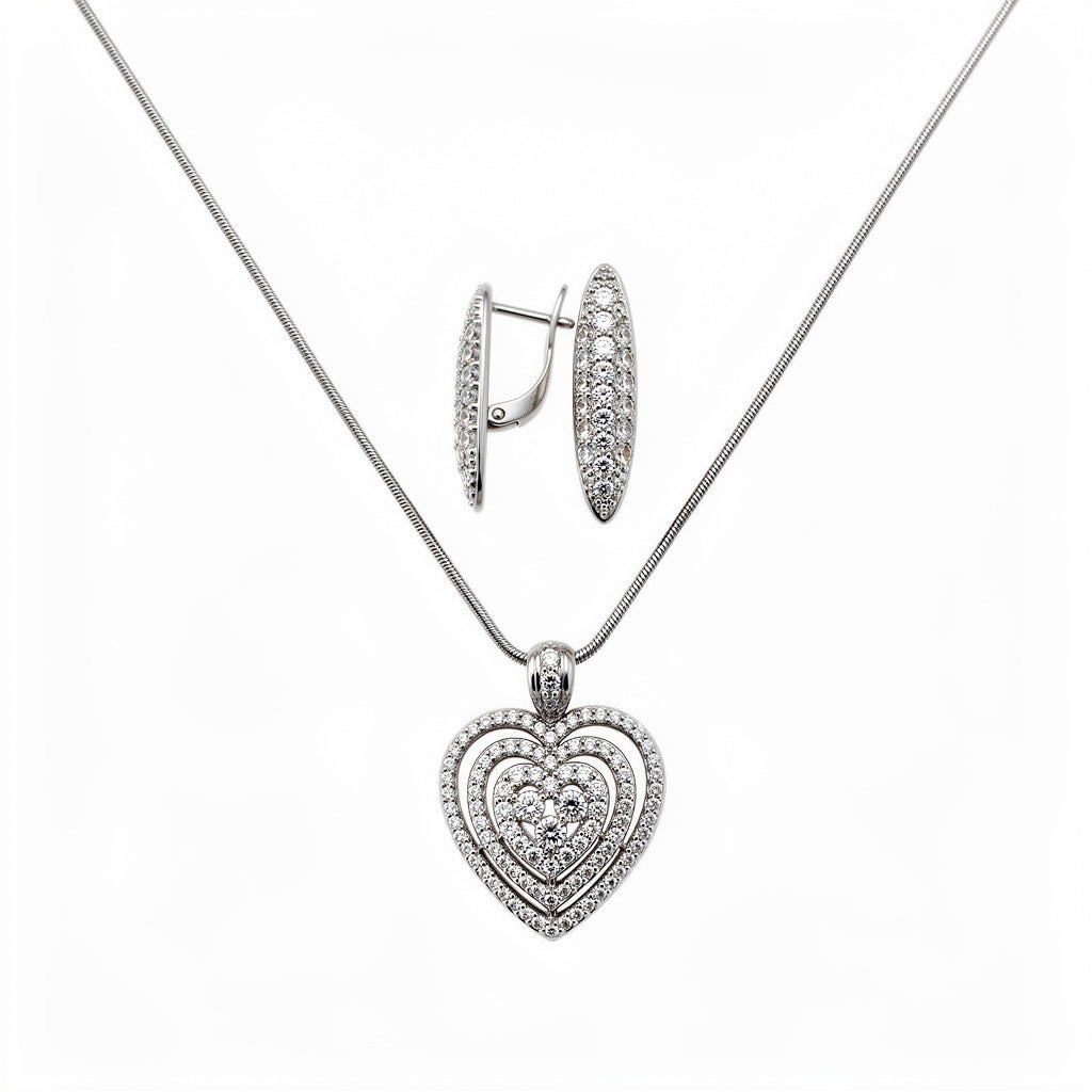 Necklace with a cubic zirconia heart pendant and long earrings in silver tone