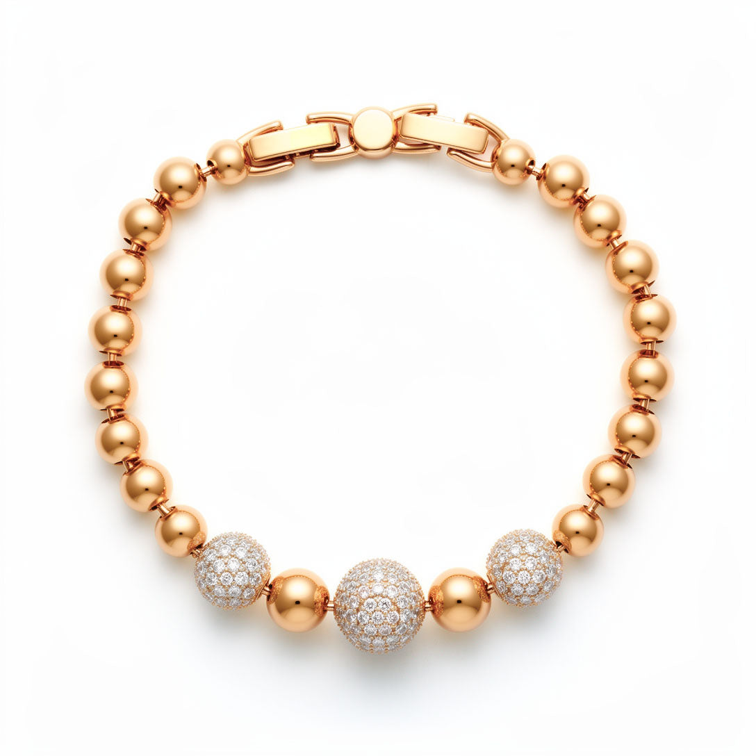 Gold-tone bracelet of smooth beads with three cubic zirconia-covered balls on white