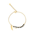 Gold-plated double chain bracelet with black faceted beads and a fine feather charm